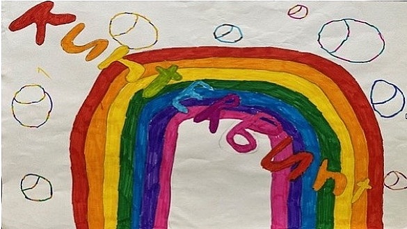 Von Kinderhand gemaltes Bild auf dem ein Regenbogen dargestellt ist. Es ist Kunterbunt zu lesen.