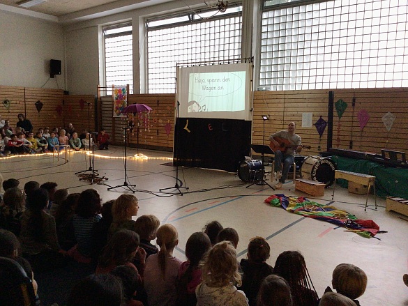Blick auf die B&uuml;hne: Xylophone, Lehrer mit Gitarre, Hinterk&ouml;pfe der Kinder