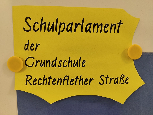Steinfigur aus vier Personen, die im Kreis stehen und sich umarmen